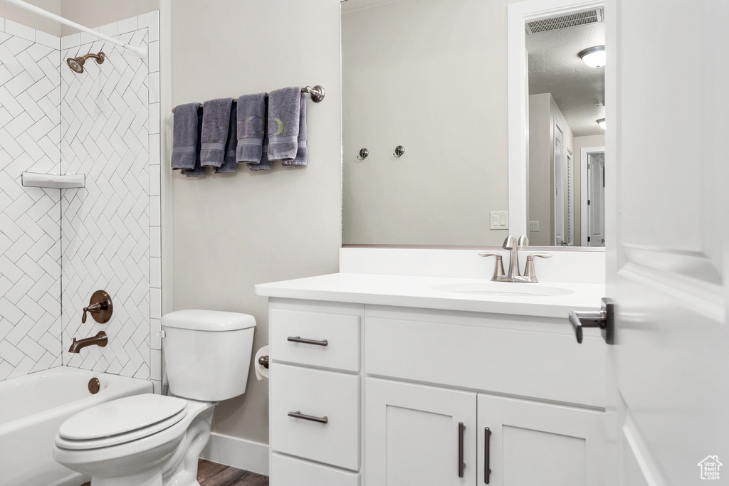 Bathroom with vanity, baseboards, bathing tub / shower combination, toilet, and visible vents