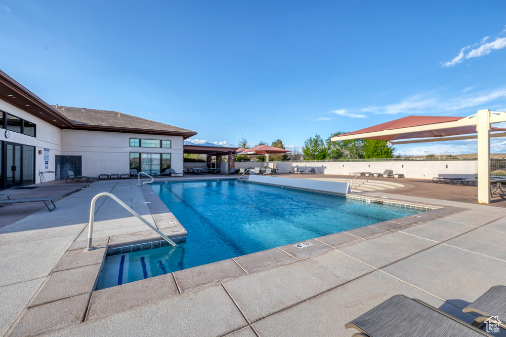 Community pool featuring a patio and fence