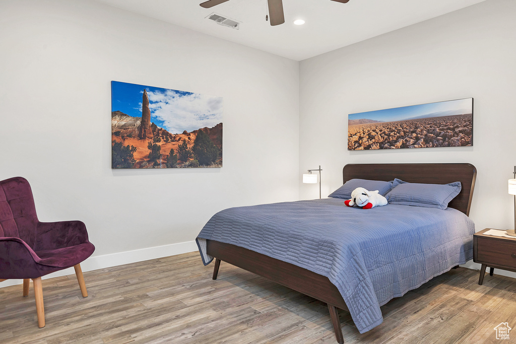 Bedroom featuring wood finished floors, baseboards, visible vents, and recessed lighting