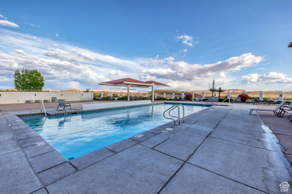 Pool with a patio area and fence