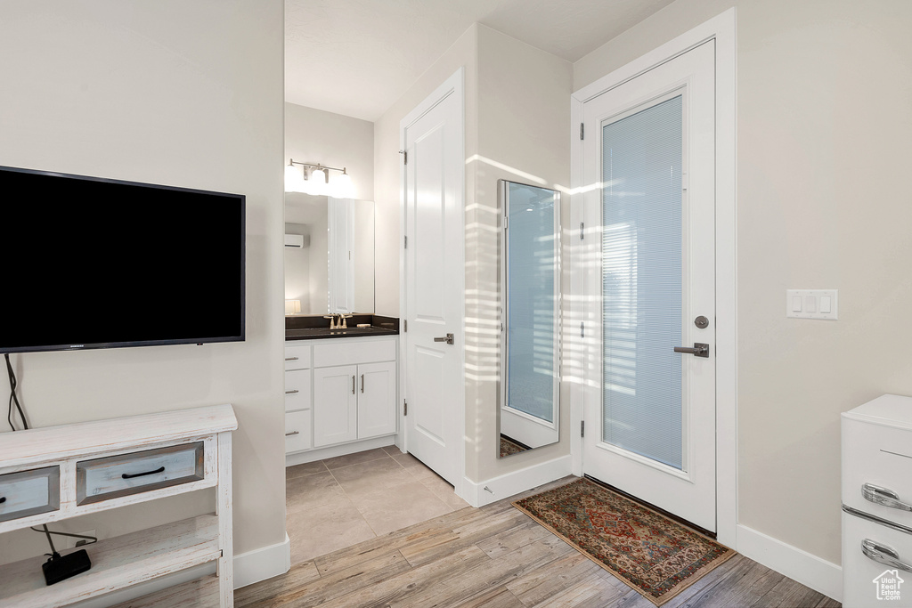 Bathroom featuring vanity, baseboards, walk in shower, and wood finished floors