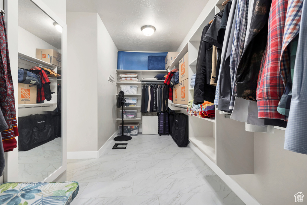 Walk in closet featuring marble finish floor