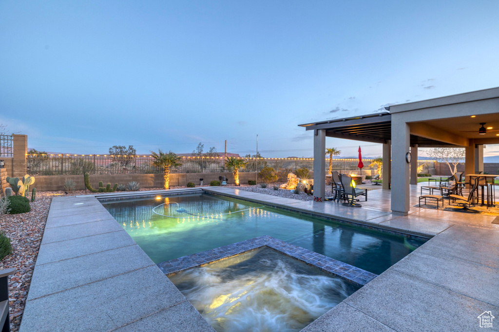 View of swimming pool with a patio, a pool with connected hot tub, and a fenced backyard
