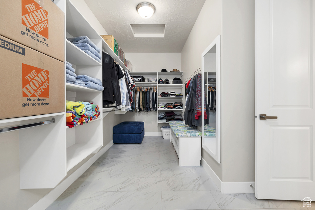 Walk in closet featuring marble finish floor