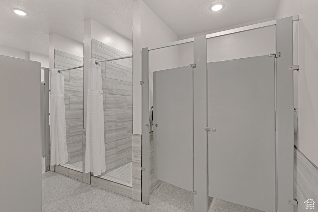 Full bathroom with tiled shower and recessed lighting