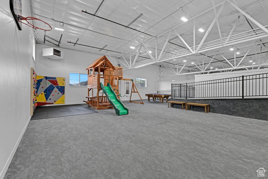Playroom featuring a towering ceiling, carpet flooring, and baseboards