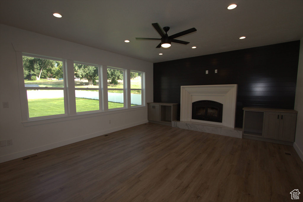 Unfurnished living room featuring a ceiling fan, visible vents, recessed lighting, wood finished floors, and baseboards