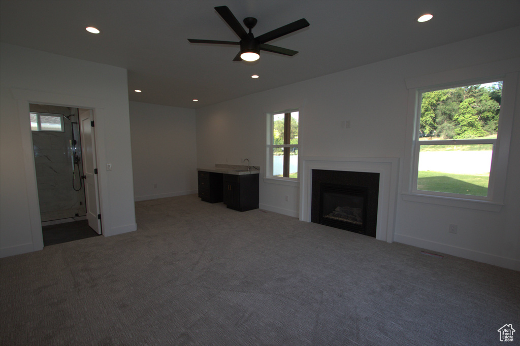 Unfurnished living room with carpet flooring, a fireplace, a ceiling fan, and recessed lighting