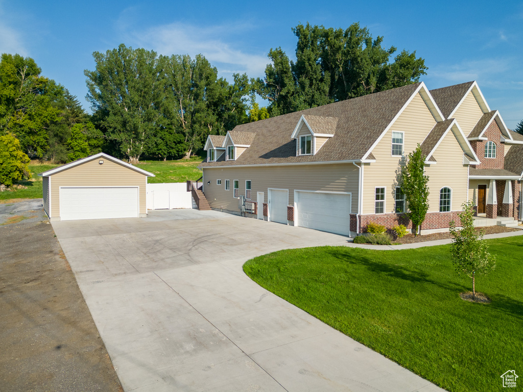 View of front of home featuring concrete driveway, roof with shingles, fence, a front lawn, and a garage