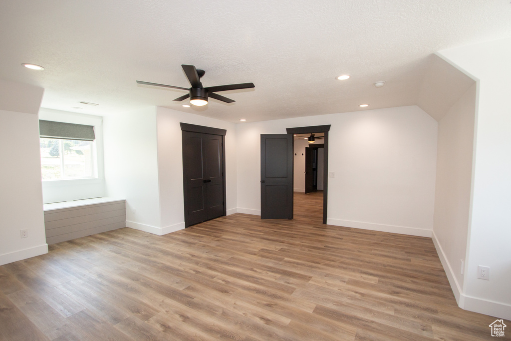 Unfurnished bedroom with light wood-style floors, ceiling fan, a textured ceiling, recessed lighting, and baseboards