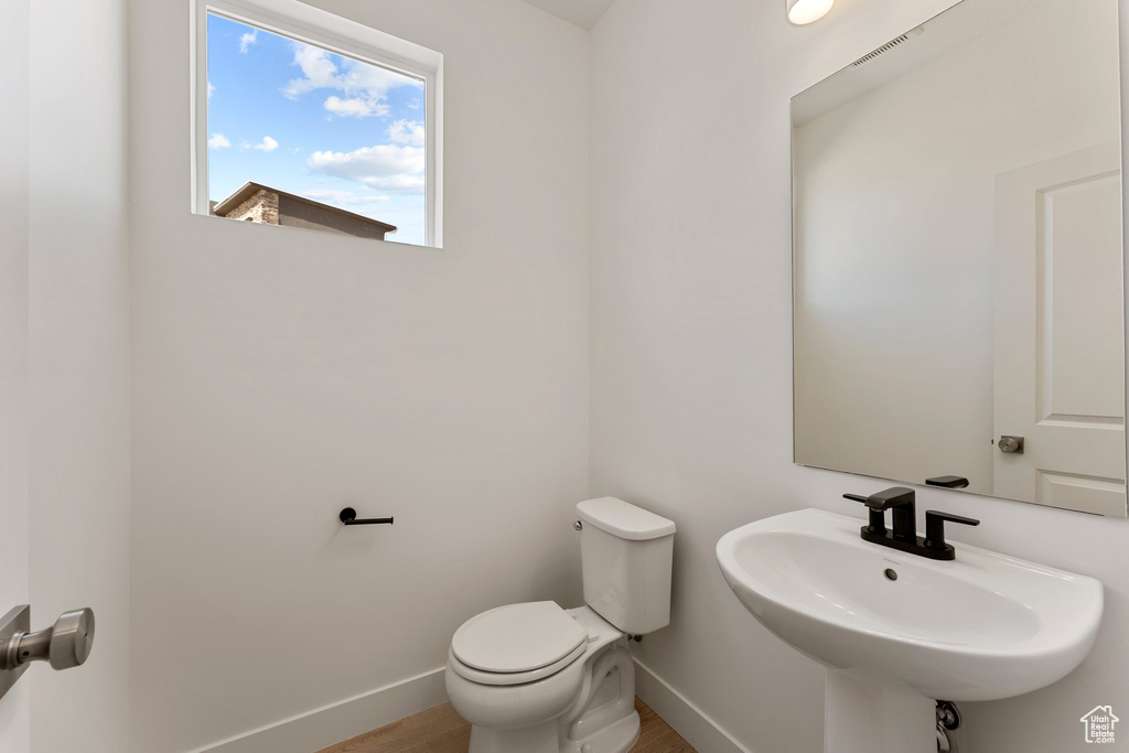 Half bathroom with a sink and wood finished floors