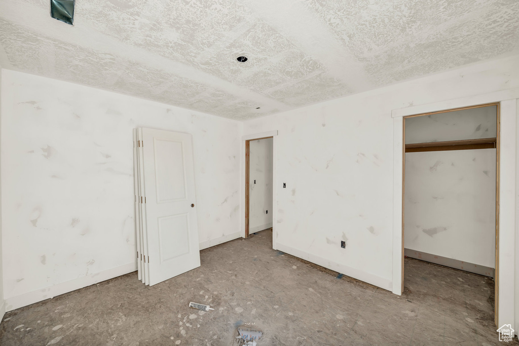 Unfurnished bedroom with a textured ceiling and baseboards