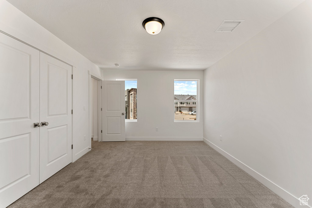 Unfurnished bedroom featuring carpet and baseboards