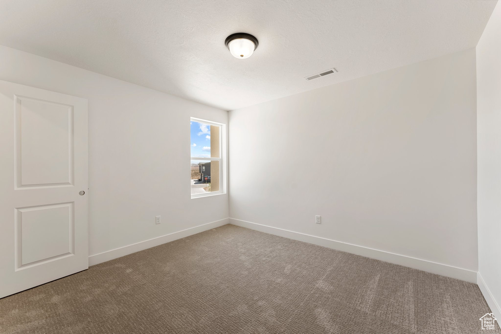 Carpeted empty room with baseboards