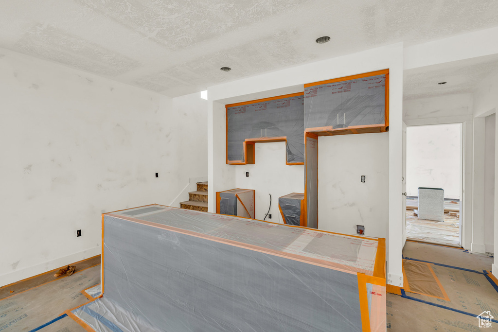 Miscellaneous room with stairs and baseboards