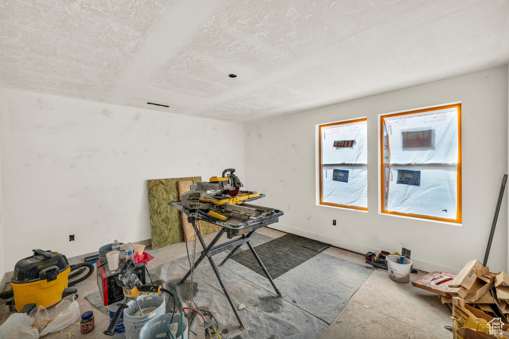 Misc room with a textured ceiling and baseboards