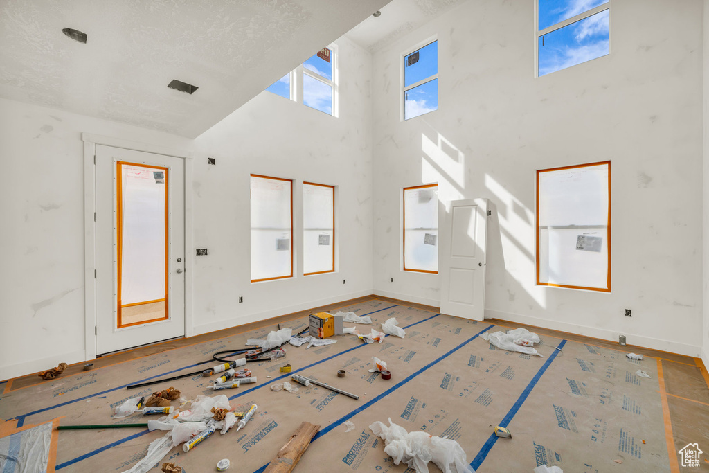 Foyer entrance with baseboards and a towering ceiling
