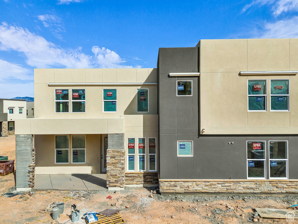 View of front of house with stucco siding and stone siding