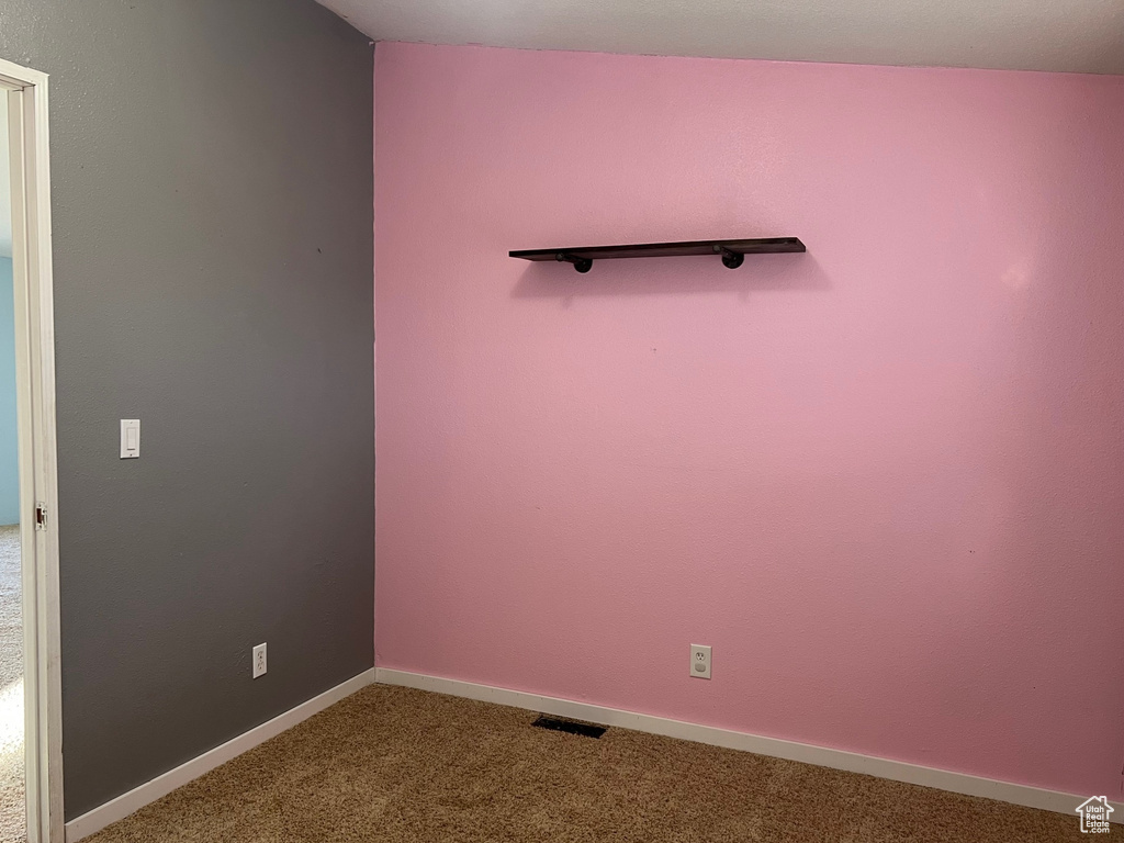 Carpeted spare room featuring baseboards and visible vents