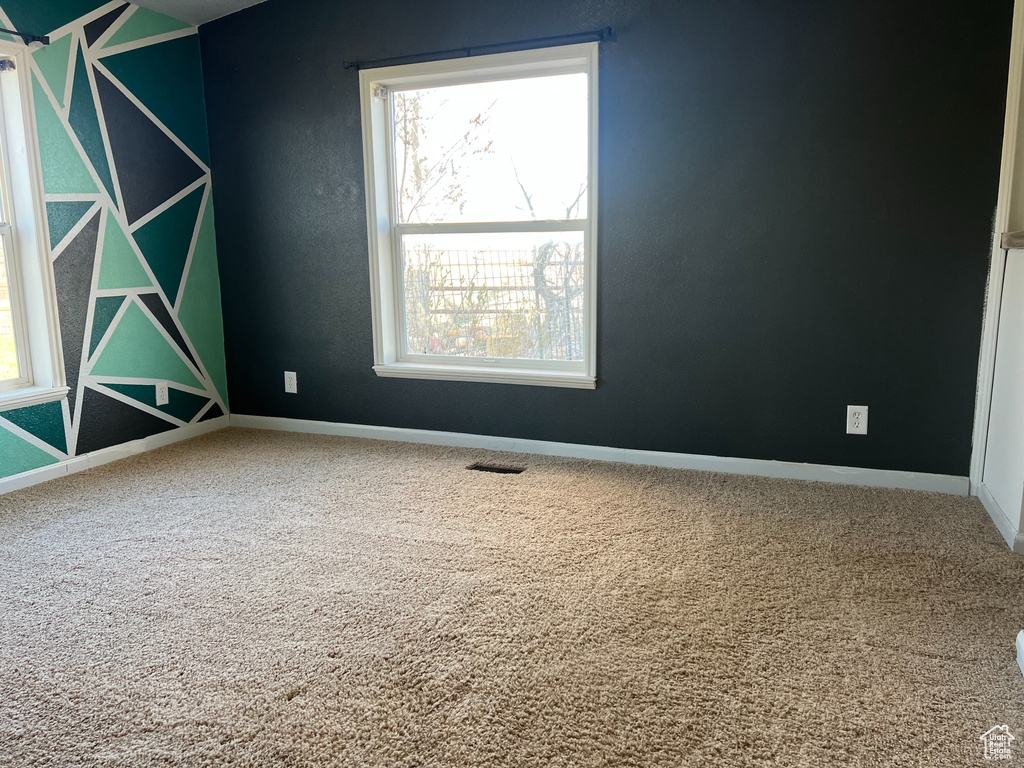 Unfurnished room with carpet, visible vents, and baseboards