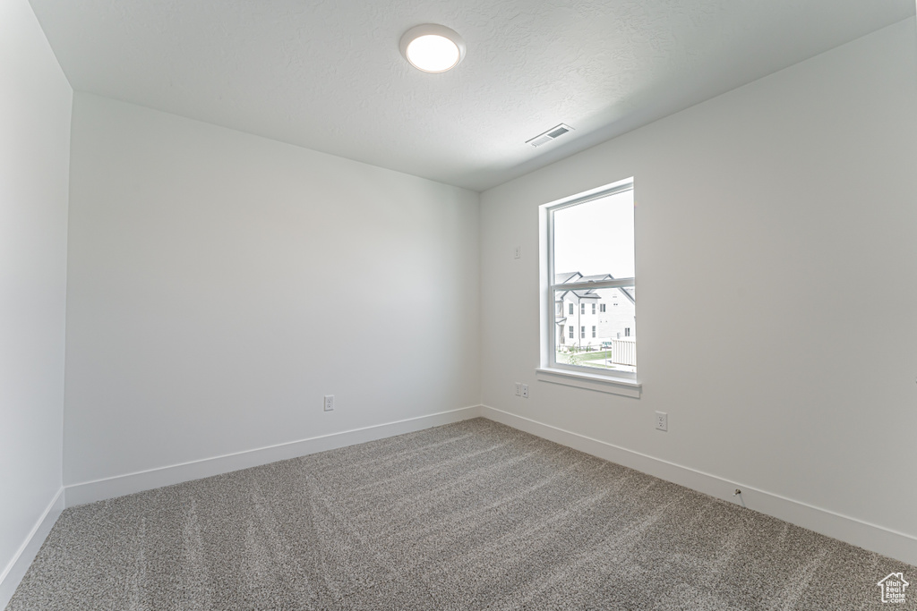 Spare room featuring carpet and baseboards