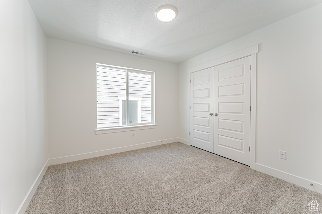 Unfurnished bedroom with carpet floors and a closet