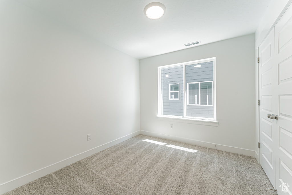 Carpeted spare room with baseboards