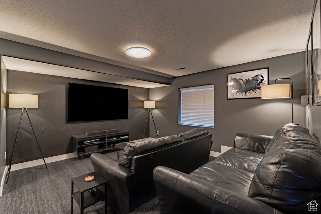 Cinema room featuring visible vents, baseboards, and a textured ceiling