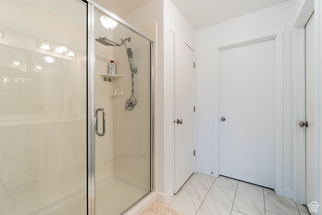Bathroom with a stall shower and marble finish floor