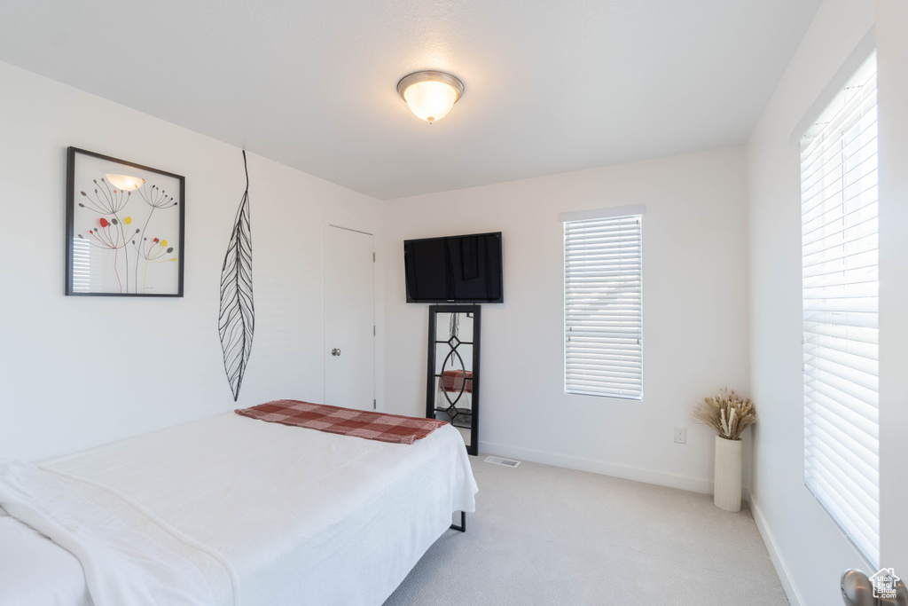 Bedroom with light colored carpet and baseboards