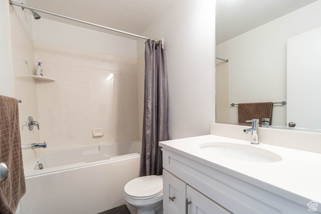 Full bathroom with shower / tub combo, vanity, and toilet
