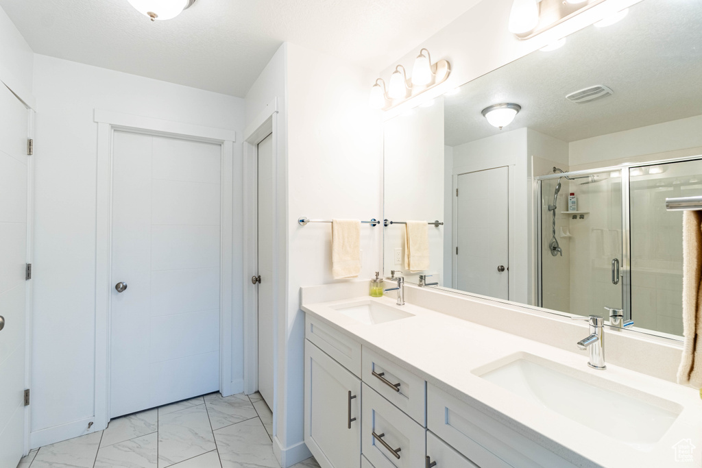 Full bath featuring a stall shower, marble finish floor, a sink, and visible vents