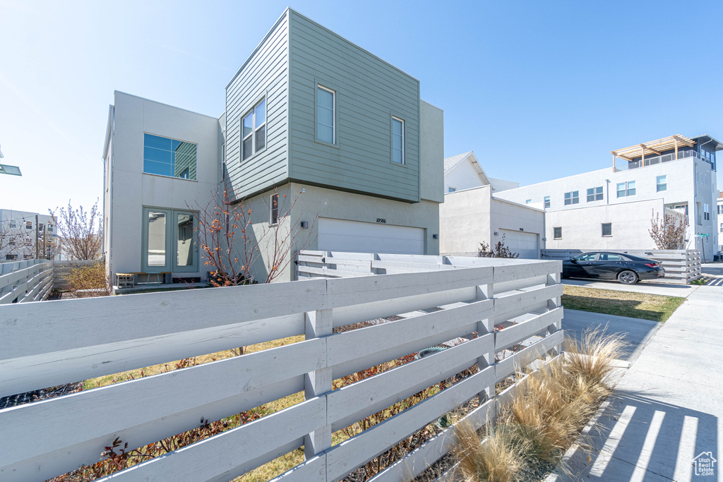 View of home\\\\\\\'s exterior with stucco siding, a garage, and a fenced front yard
