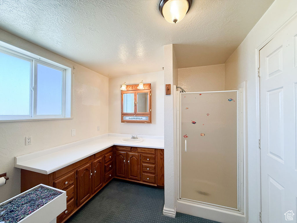 Bathroom with a shower stall, vanity, and a textured ceiling