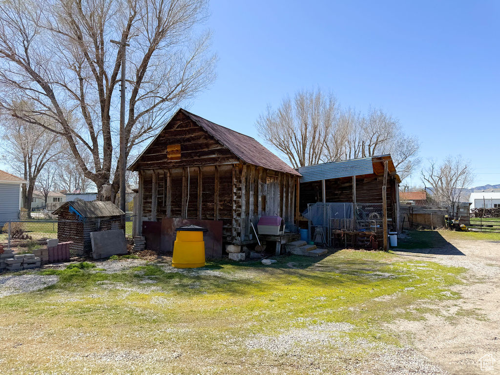 Back of house featuring a storage shed, an outbuilding, and a yard