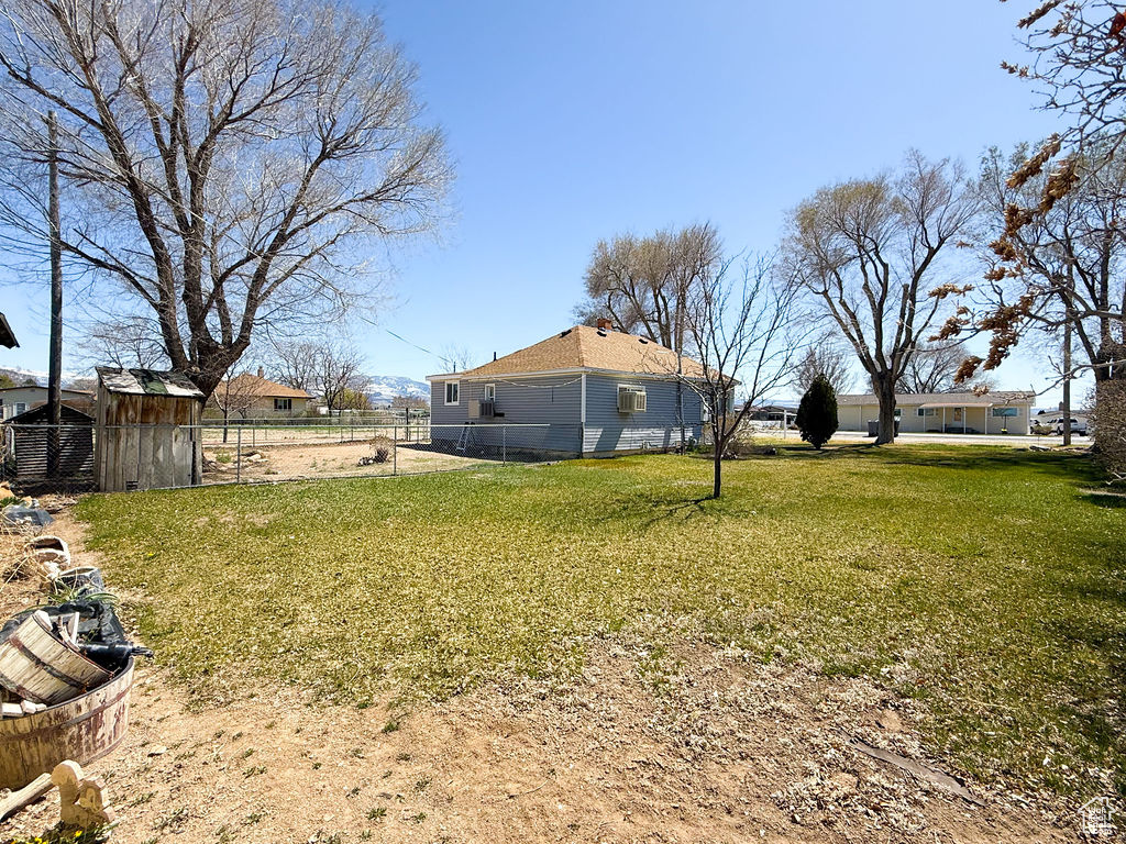View of yard featuring an outdoor structure and fence
