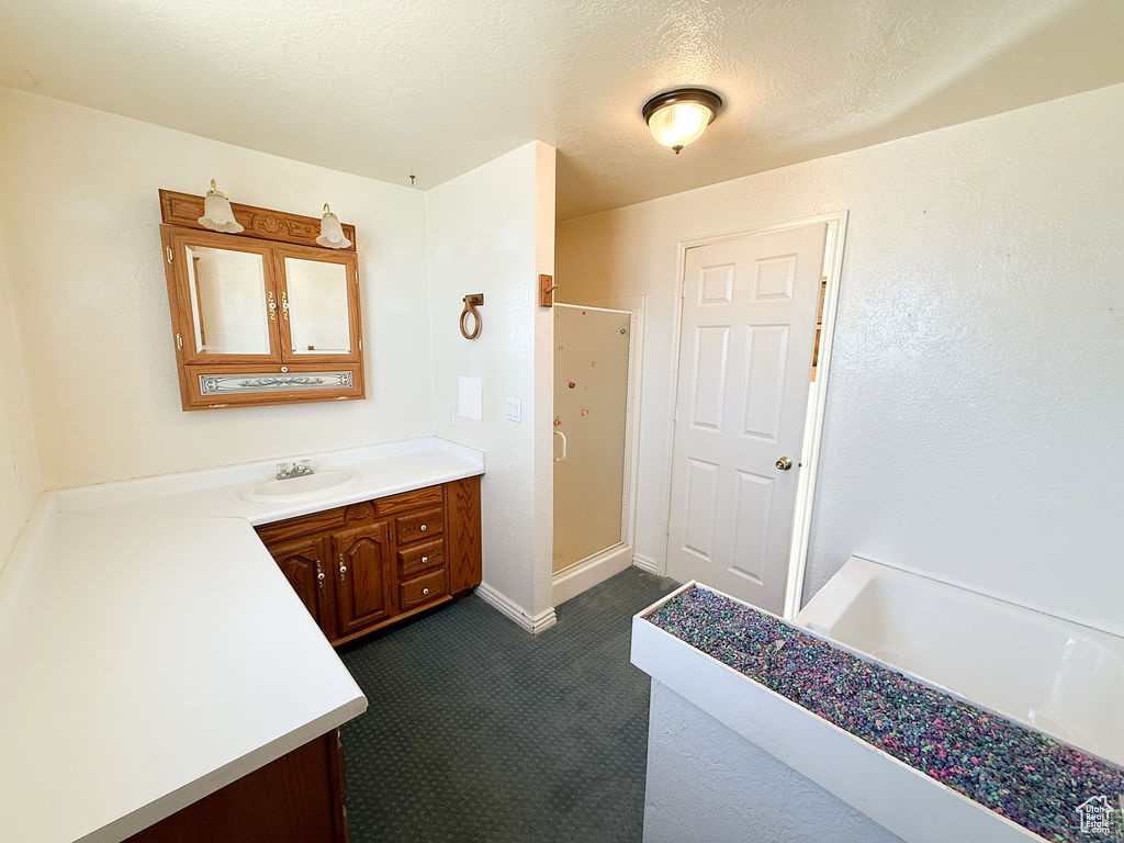Bathroom with vanity, a stall shower, and a textured ceiling