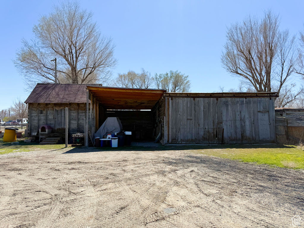 View of pole building with driveway and an attached carport