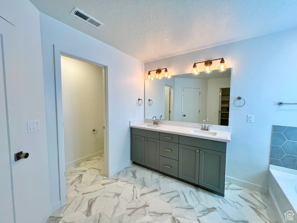Full bath with a sink, marble finish floor, and visible vents