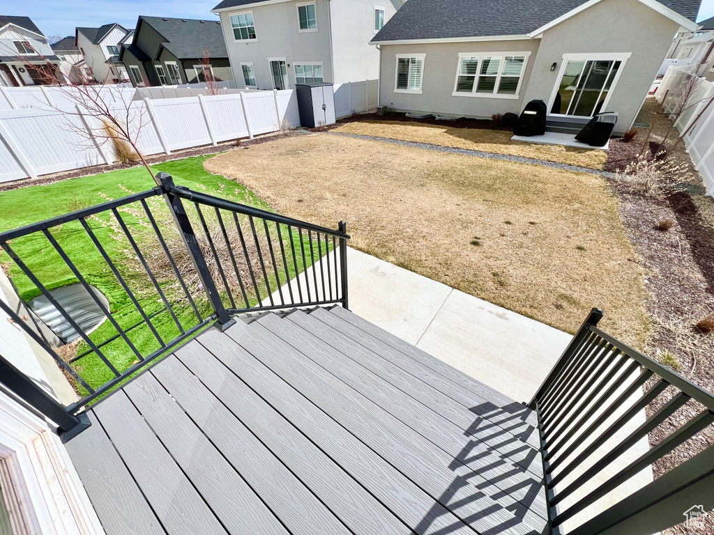 Wooden terrace with a fenced backyard, a residential view, and a patio