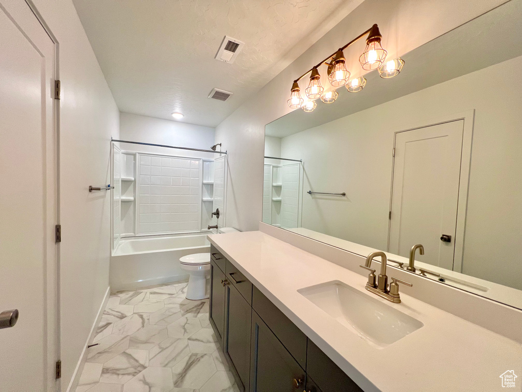 Full bathroom featuring vanity, toilet, a textured ceiling, marble finish floor, and visible vents