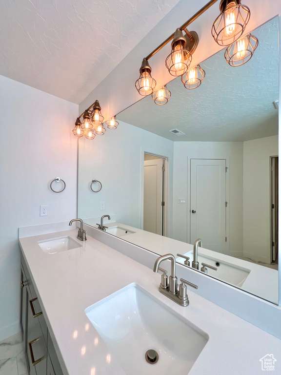 Bathroom featuring a sink and a textured ceiling