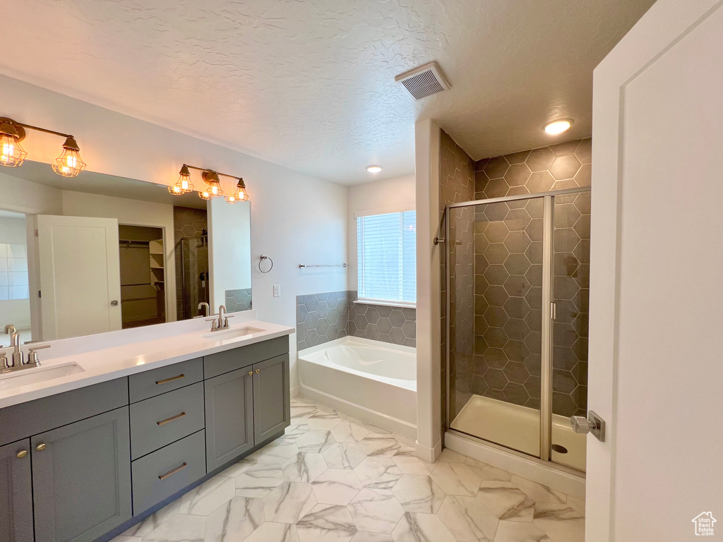 Bathroom with a stall shower, visible vents, marble finish floor, and a sink