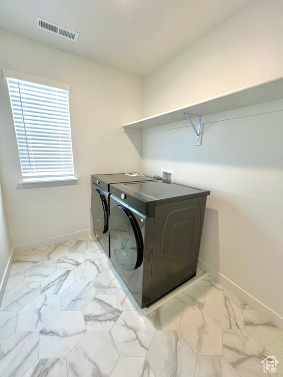 Laundry room with baseboards, marble finish floor, visible vents, and laundry area