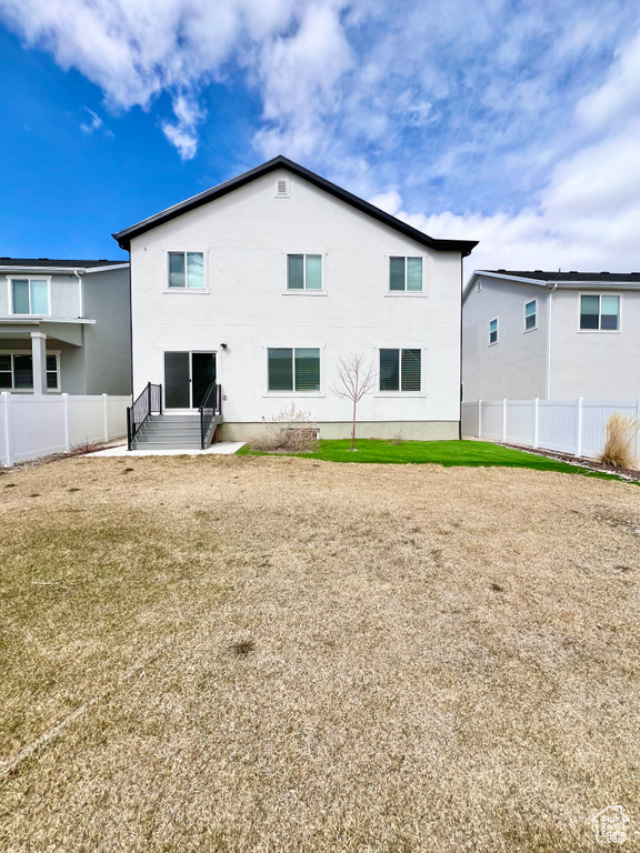 Back of property with a lawn, fence, and entry steps