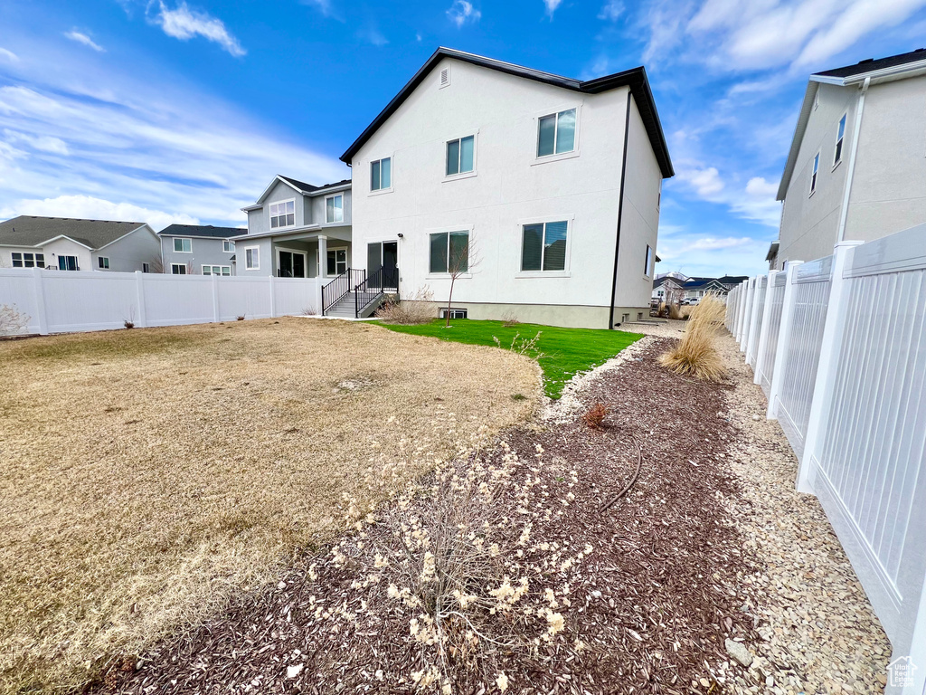 Back of house featuring a lawn and a fenced backyard