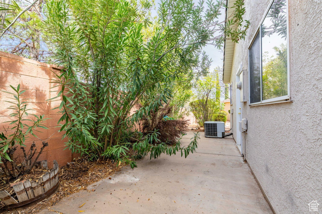 View of patio featuring central AC and fence