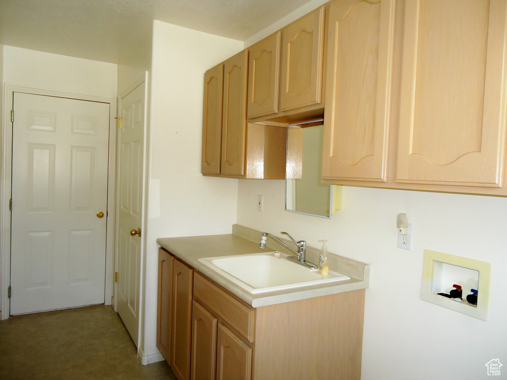 Kitchen featuring light countertops, light brown cabinets, and a sink