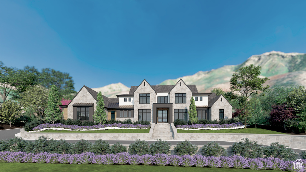View of front of home with a mountain view, stone siding, metal roof, and a standing seam roof