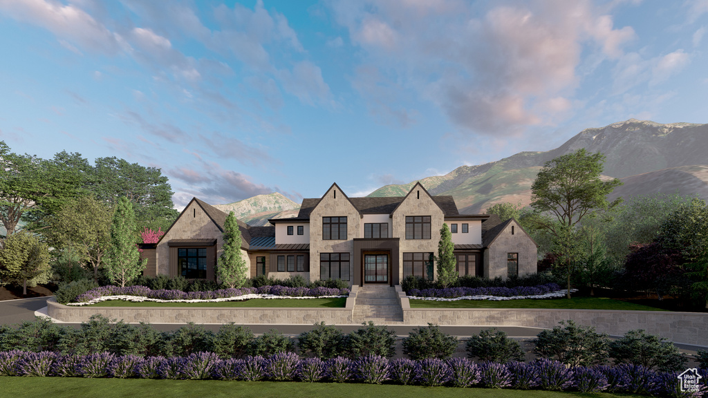 View of front of house featuring a mountain view, stone siding, metal roof, and a standing seam roof